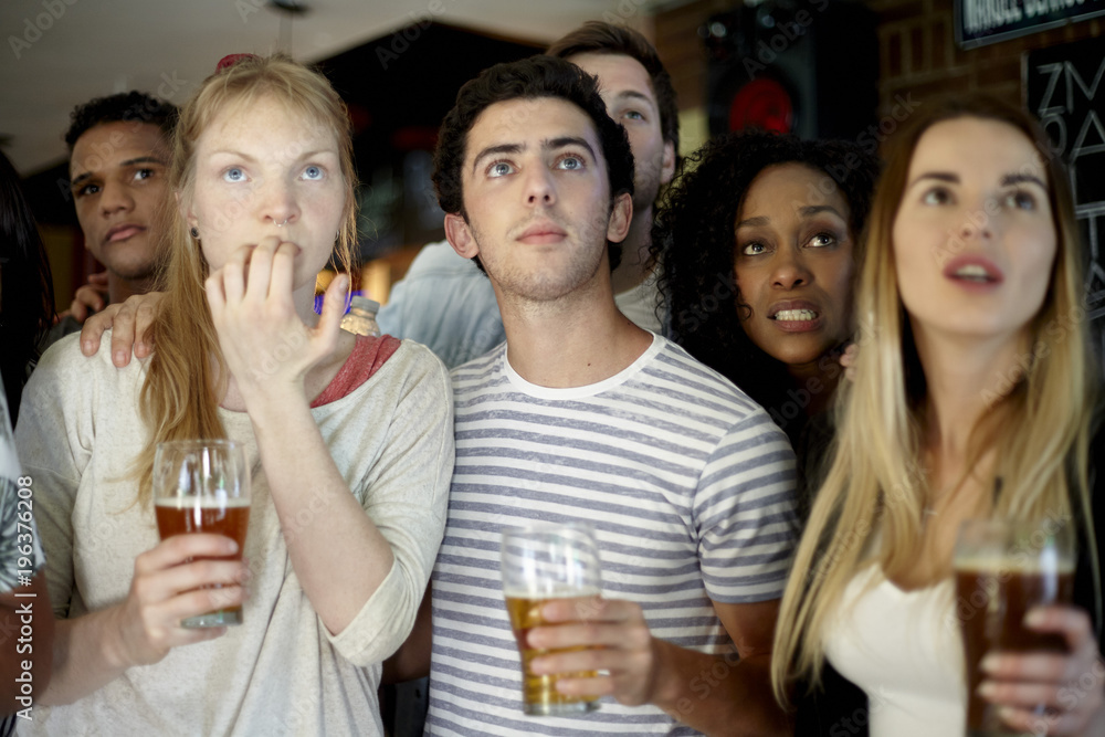 Soccer fans watching soccer match together at a pub Soccer fans watching soccer match together at a pub