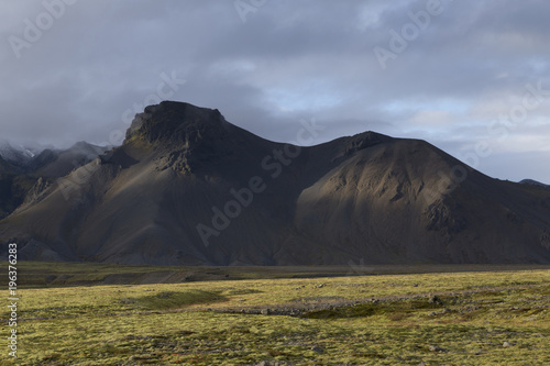 Island südliche Küste, vulkanische schroffe Berge im Gegensatz zu den grünen Wiesen photo