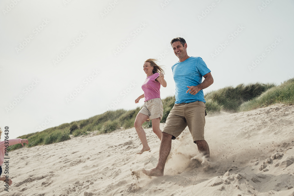 Couple Running Down a Sand Dune