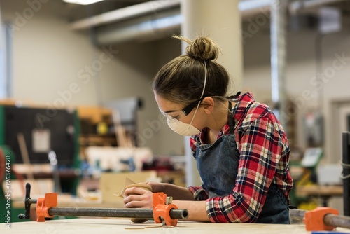 Female carpenter working in workshop photo