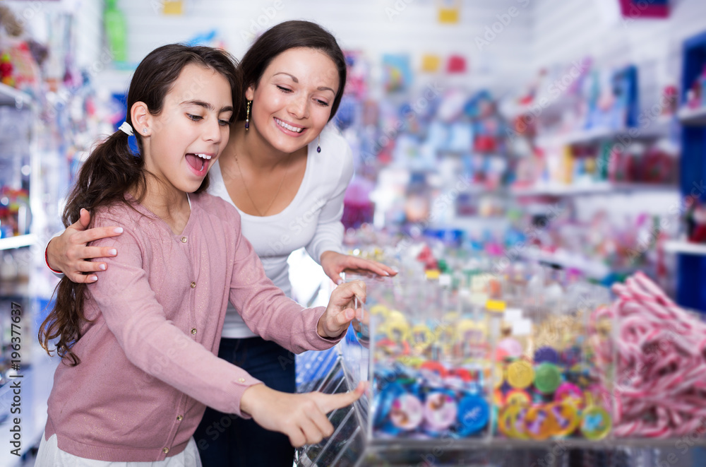 Mother with daughter delighted with choosing lollipop