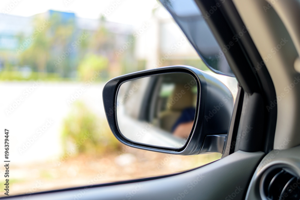 car side mirror window with soft-focus in the background. over light