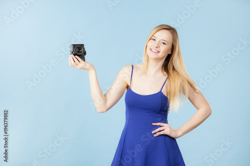 Blonde woman with camera on blue