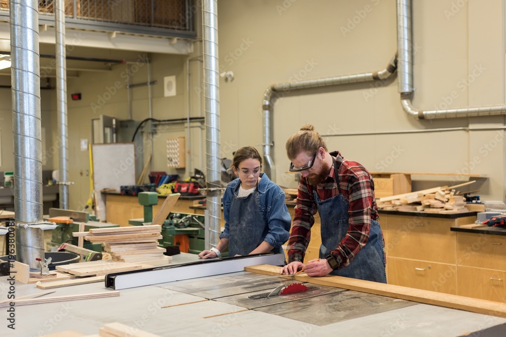 Male and female carpenters working together Male and female carpenters working together