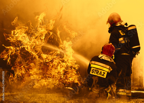 Fototapeta firefighters extinguishing a dangerous fire