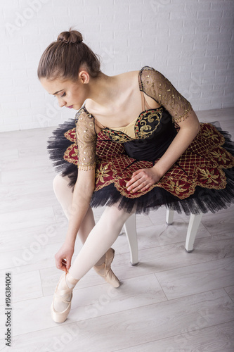 Yooung ballerina sitting on the chair and concentrate for performans photo