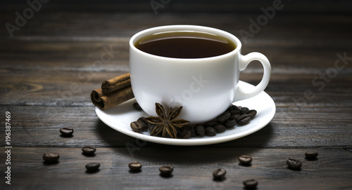 cup of coffee with grains on a wooden background
