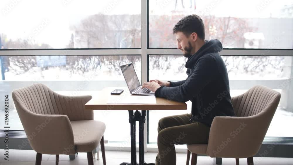 a young businessman works in a cafe with a laptop a young businessman works in a cafe with a laptop