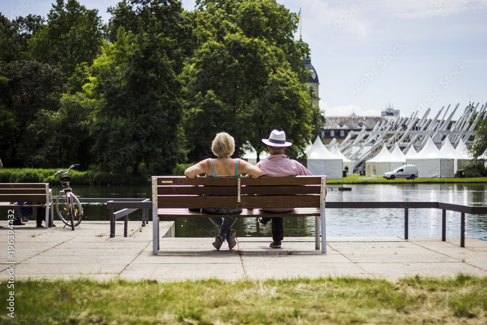 Couple sitting in front of a pond