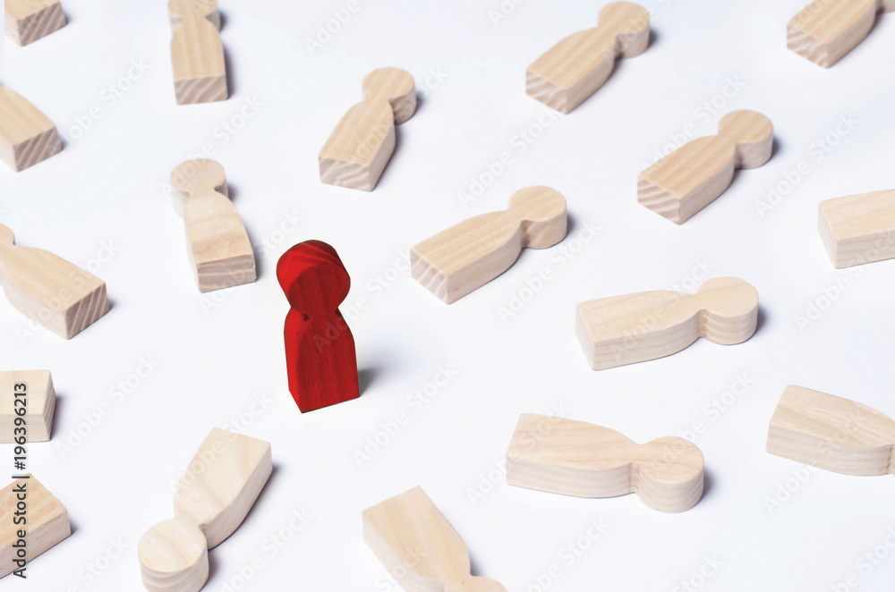Not like everyone else. The red man stands in the middle of lying opponents. The concept of excellence, business success. An outcast, a schismatic, a bad person. Wooden human figures. Not like everyone else. The red man stands in the middle of lying opponents. The concept of excellence, business success. An outcast, a schismatic, a bad person. Wooden human figures.