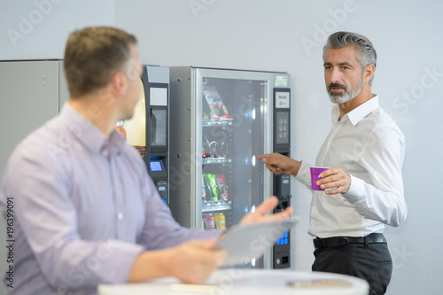 Fotografie man taking coffee from vending machine