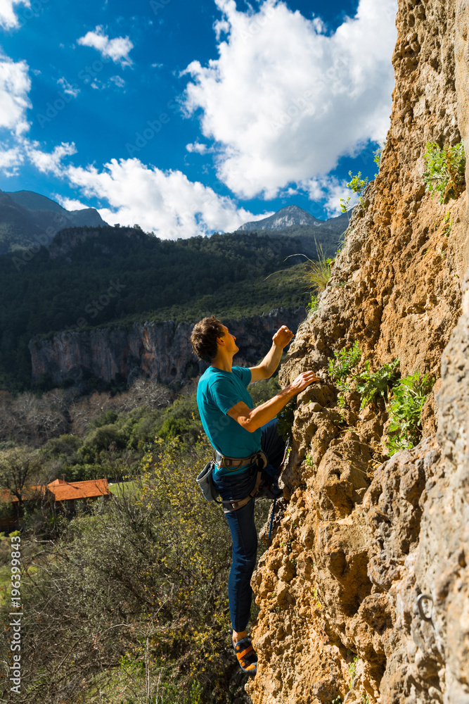 Obraz premium rock-climber climbs route with lower insurance