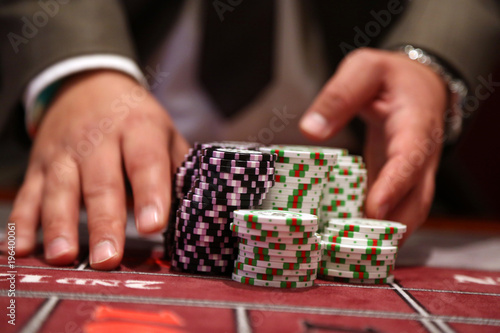 Player at gambling table pusing large stack of chips
