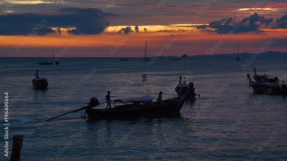Silhouettes of a group of a long-tail boats moored on the coast at sunset Silhouettes of a group of a long-tail boats moored on the coast at sunset