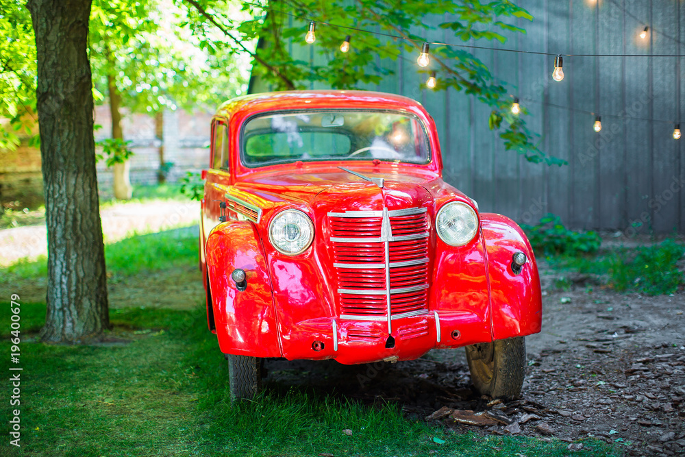 Old red car in the park in summer