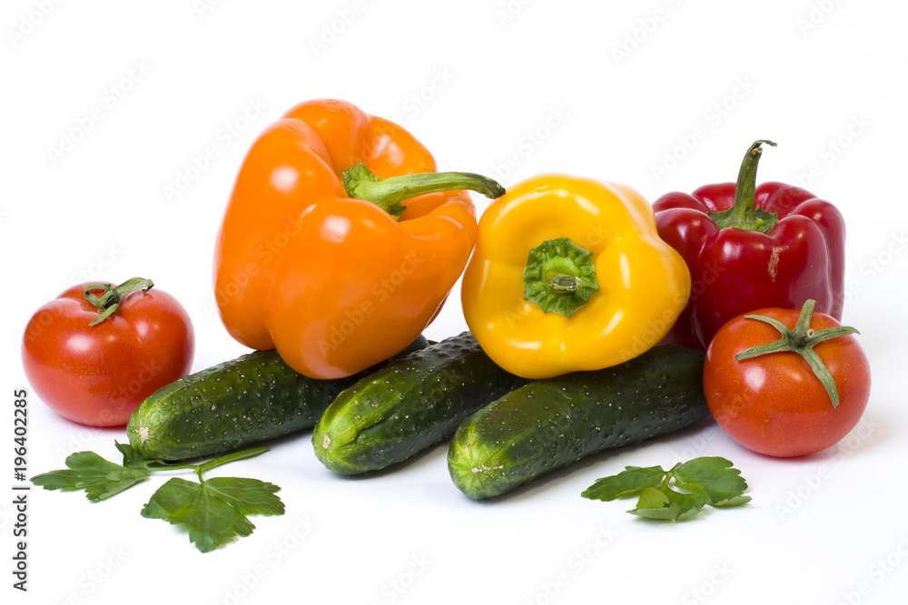 Red yellow and orange peppers with tomatoes on a white background. Cucumbers with colorful peppers in composition on a white background Red yellow and orange peppers with tomatoes on a white background. Cucumbers with colorful peppers in composition on a white background