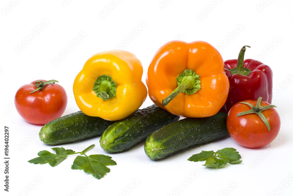 Red yellow and orange peppers with tomatoes on a white background. Cucumbers with colorful peppers in composition on a white background Red yellow and orange peppers with tomatoes on a white background. Cucumbers with colorful peppers in composition on a white background