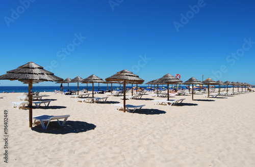 Many Umbrellas on the beach with blue sky in Tavira island Portugal
