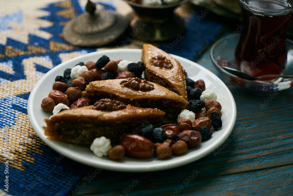 custom made wallpaper toronto digitalAzerbaijan national pastry pakhlava with sweet snack and glass of traditional black tea on wooden table with green semeni wheat grass background , Novruz tray spring celebration