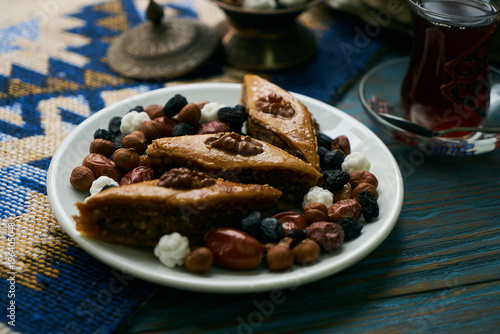 Wallpaper Mural Azerbaijan national pastry pakhlava with sweet snack and glass of traditional black tea on wooden table with green semeni wheat grass background , Novruz tray spring celebration Torontodigital.ca