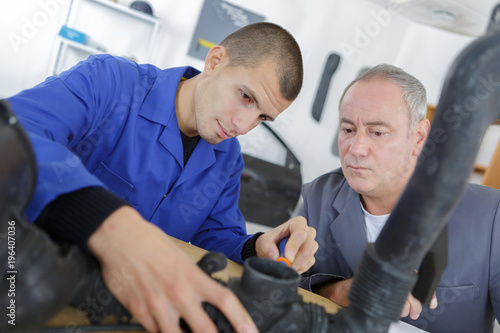mechanic and male trainee working together