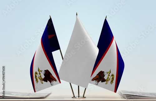 Two flags of American Samoa with a white flag in the middle photo