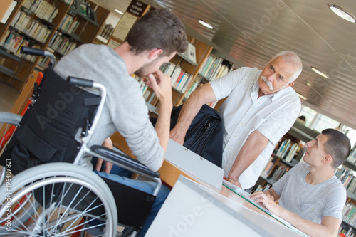 handicapped teenager doing his homework with teacher