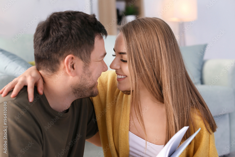 Naklejka premium Cute young lovely couple reading book at home
