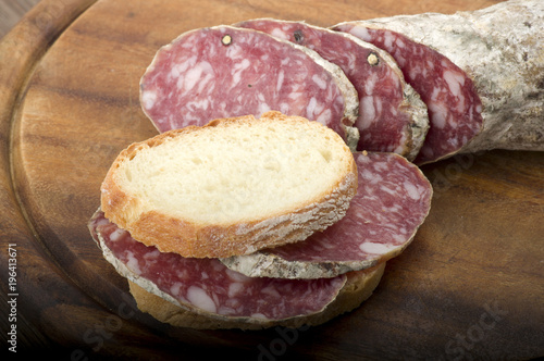 wooden cutting board with salami and bread