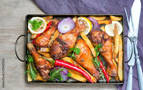 Grilled spicy chicken legs with pepper, lemon and potatoes photo