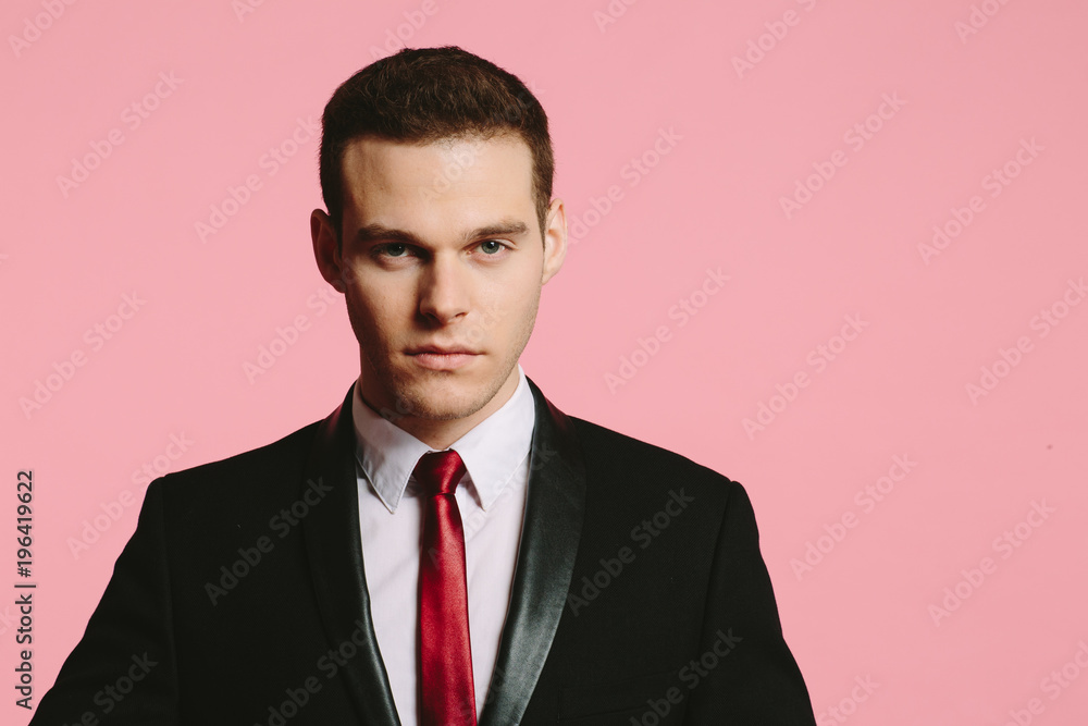 Φωτογραφία Close up portrait of a handsome young man in black suit and tie looking at camer