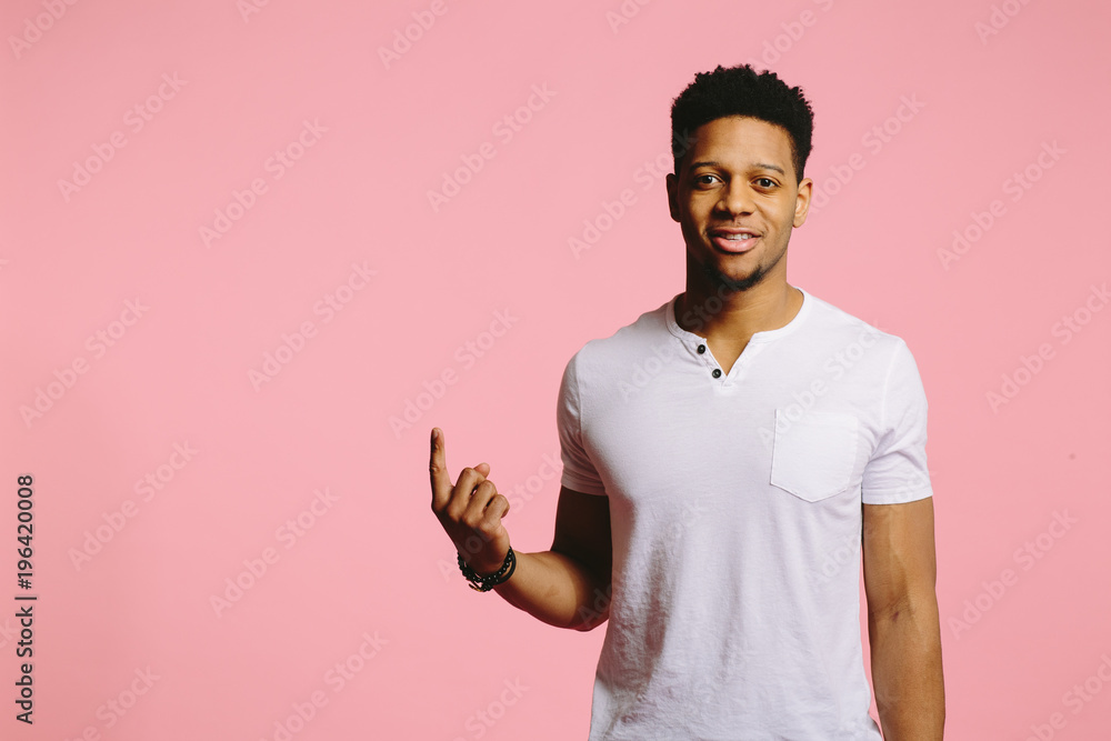 Portrait of a handsome African American guy pointing up looking at camera Portrait of a handsome African American guy pointing up looking at camera