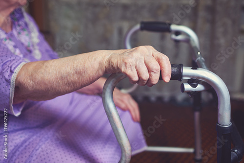 Elderly woman using a walker at home.