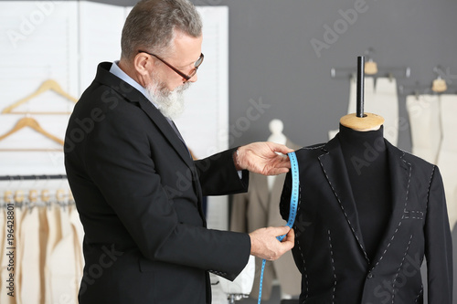 Senior tailor taking measur...