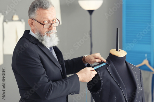 Senior tailor taking measur...