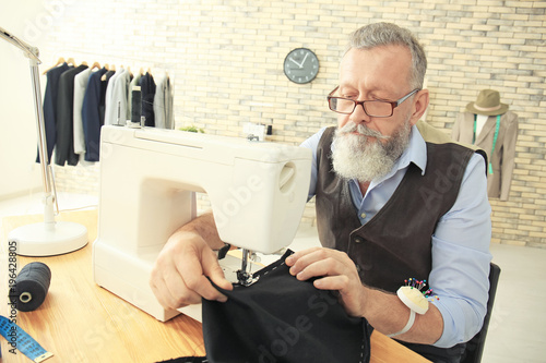 Senior tailor working on se...