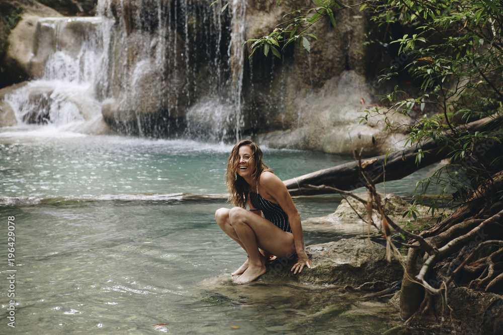 Fototapeta premium Woman sitting in a natural pond