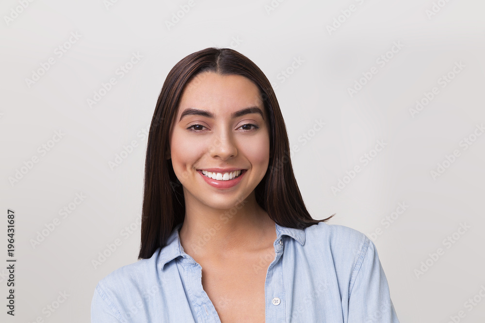 Portrait image of smiling Hispanic woman with long hair and blue shirt Portrait image of smiling Hispanic woman with long hair and blue shirt