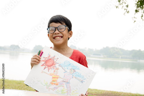Asian boy wear red t-shirt show his picture with garden and pond scene
