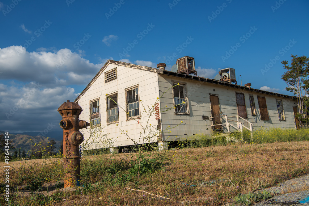 Abandoned building with an old fire hydrant in the foreground and old ...