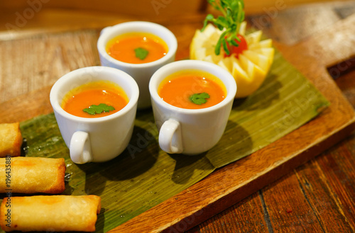 Tomato soup in mini coffee cups served at a catered party
