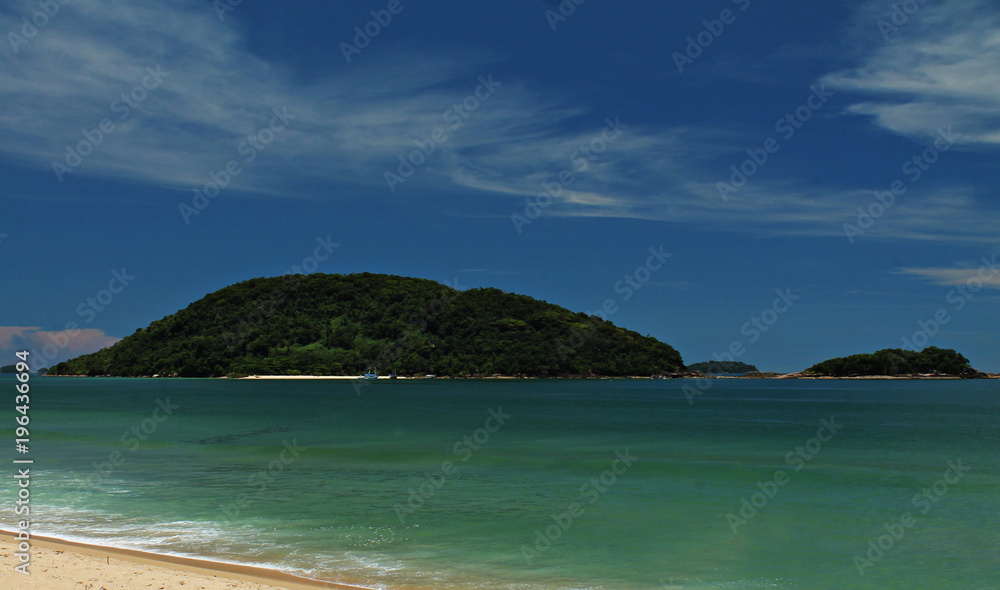 Prumirim Island, Ubatuba, Sao Paulo, Brazil - Paradise tropical beach with white sand, blue and calm waters, without people on a sunny day and blue sky of the Brazilian coast in high resolution