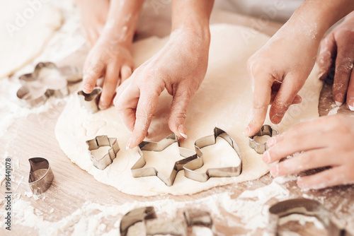 Tableau sur toile Female and children's hands make form for biscuits with help of baking molds