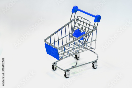 Close the grocery store in the supermarket and push the shopping cart with the blue handle isolated from the White background. Shop concept