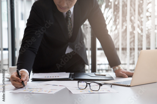 Bisiness Man checking Business plan on document on desk in office