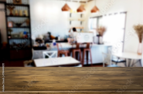 Selected focus empty brown wooden table and Coffee shop or restaurant blur background with bokeh image. for your photomontage or product display.