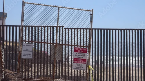 Signs warn of a restricted area at the U.S. Mexico border fence in the Pacific Ocean between San Diego and Tijuana. photo