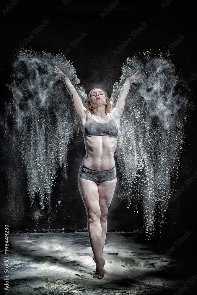 Girl dansing with flour on black background