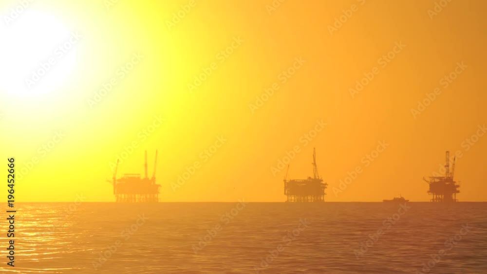 Day to night time lapse of the sun setting behind three oil platforms in the Santa Barbara Channel, California. Day to night time lapse of the sun setting behind three oil platforms in the Santa Barbara Channel, California.