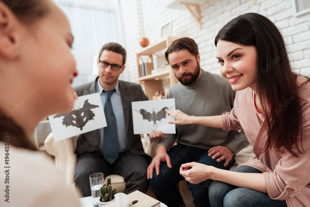 Little girl pass Rorschach test together with her parents in office of psychologist. Little girl pass Rorschach test together with her parents in office of psychologist.